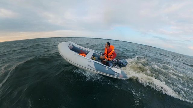 A man in a life vest is driving a powerboat