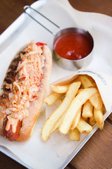 Hot dog served on plate with french fries