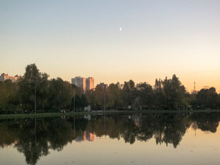 Fototapeta premium Autumn time, autumn in the city, urban autumn landscape with a pond, people walking and other fun