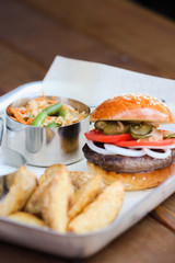 Tasty Hamburger with beef meat, potatoes, salad, tomato and onion