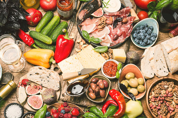 Top view table full of food. Italian antipasti wine snacks set. Cheese variety, nuts, olives,...