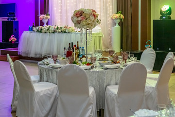 Tables and chairs decorated in white on wedding party in restaurant