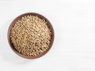 Cumin seeds (Cuminum), Jeera on clay plate on a white wooden background with copy space