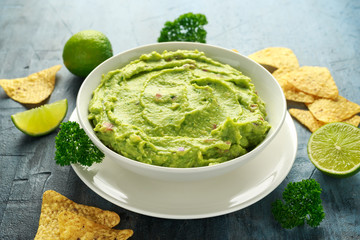 Bowl of fresh Guacamole with nachos chips and herbs. Healthy Vegan, Vegetables food.