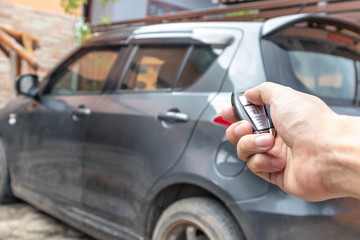 Fototapeta premium A man opening his car door with pushing button on control remote key.