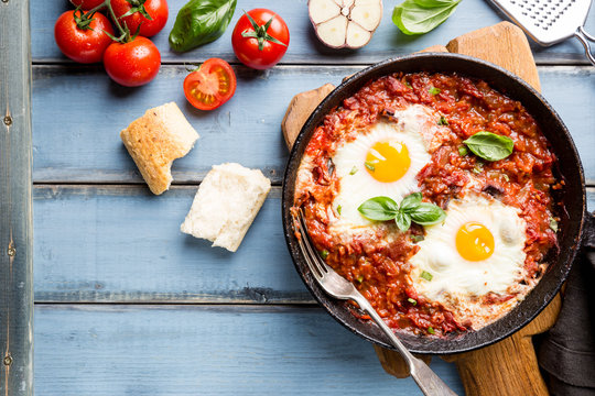 Shakshuka, Fried Eggs in Tomato Sauce in iron frying pan. Typical Israel food. Top view.