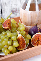 White grapes, figs and italian spirit Grappa on wooden tray. Still life