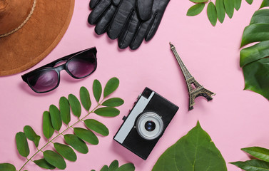 Jorney to Paris. Women's accessories, retro camera, figurine of the Eiffel tower on pink pastel...