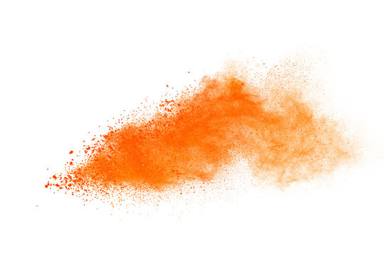 Abstract orange powder explosion. Closeup of orange dust particle splash isolated on white background