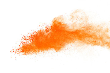 Abstract orange powder explosion. Closeup of orange dust particle splash isolated on white...