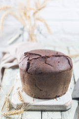 Fresh homemade traditional round rye bread on rustic wooden background
