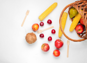 Picnic setting with bassket and fruit on white background.  Top view