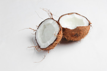 Two halves of chopped coconut on a white background