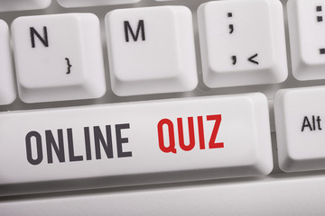 Text sign showing Online Quiz. Business photo text game or a mind sport that are published on the Internet White pc keyboard with empty note paper above white background key copy space