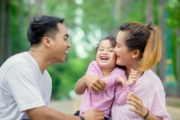 Fototapeta premium Happy child chatting with her parents in the park