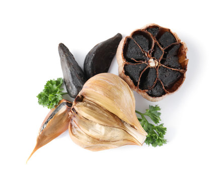 Aged black garlic with parsley on white background, view from above