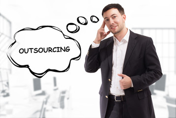 Business, technology, internet and network concept. The young businessman comes up with the keyword: Outsourcing