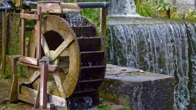 Still slow motion shot a waterwheel and a manmade waterfall.