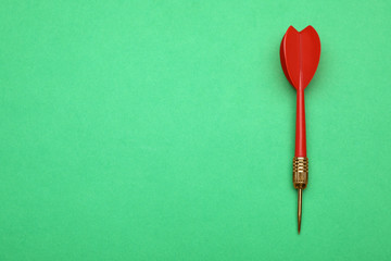 Red dart arrow on green background, top view with space for text