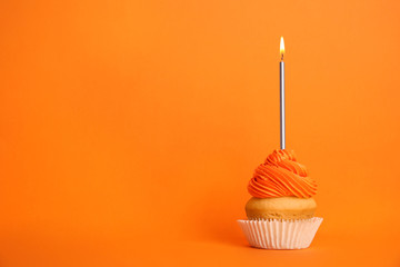 Birthday cupcake with candle on orange background, space for text