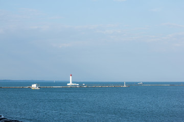 in the distance a lighthouse in Odessa cargo port on the Black Sea