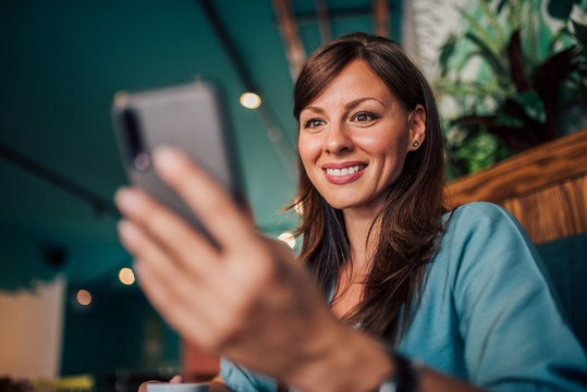 Close-up Portrait Of A Happy Woman Using Smartphone, Low Angle Image.