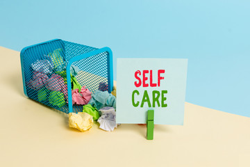 Text sign showing Self Care. Business photo showcasing the practice of taking action to improve one s is own health Trash bin crumpled paper clothespin empty reminder office supplies tipped