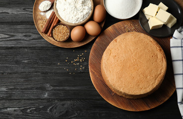 Flat lay composition with delicious fresh homemade cake on black wooden table