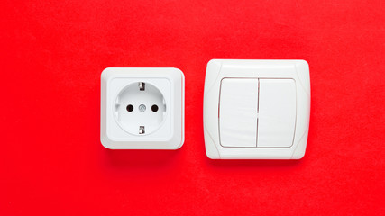 Electro socket, switch on red wall background, minimalism