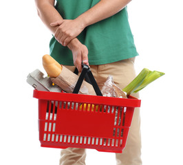 Fototapeta premium Young man with shopping basket full of products isolated on white, closeup