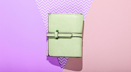 Green leather wallet on pastel background. Top view