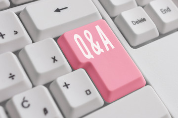 Conceptual hand writing showing Q And A Question. Concept meaning in which demonstrating asks questions and another one answers them White pc keyboard with note paper above the white background