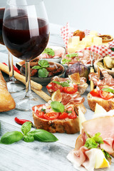 Italian antipasti wine snacks set. Cheese variety, Mediterranean olives, Prosciutto di Parma, tomatoes, artichokes