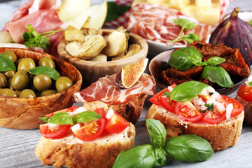 Italian antipasti wine snacks set. Cheese variety, Mediterranean olives, Prosciutto di Parma, tomatoes, artichokes