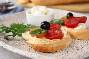 Plate of delicious tomato bruschettas on table, closeup