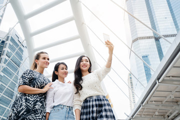 International Women Group Standing happily taking pictures of selfies in the city Summer travel is ideal for finding information from smartphones such as tourist sites, shopping and street food.