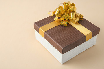 Beautiful gift box with bow on beige background