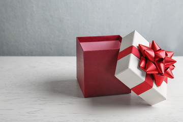 Beautiful gift box on white wooden table. Space for text