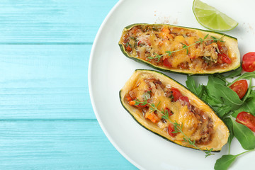 Delicious stuffed zucchini on light blue wooden table, top view. Space for text