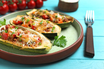 Delicious stuffed zucchini served on light blue wooden table, closeup