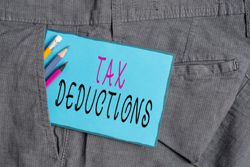 Conceptual hand writing showing Tax Deductions. Concept meaning an amount or cost that subtracted from someone s is income Writing equipment and blue note paper in pocket of trousers