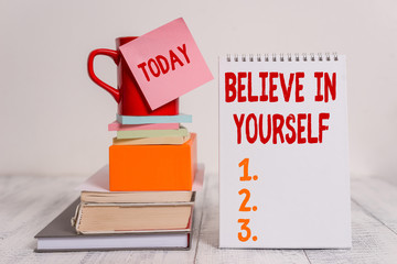 Word writing text Believe In Yourself. Business photo showcasing common piece of advice that you can do everything Cup sticky note stacked note pads books square box spiral wooden table