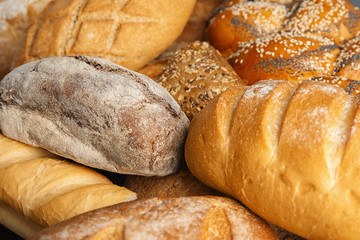 Loaves of different breads as background, closeup