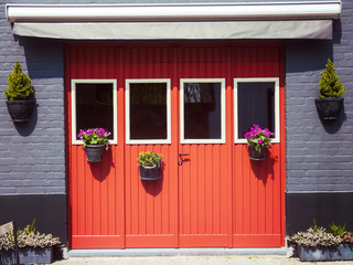 Rustic entrance with red doors and flower decoration