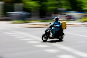 home delivery company carrier driving his motorcycle