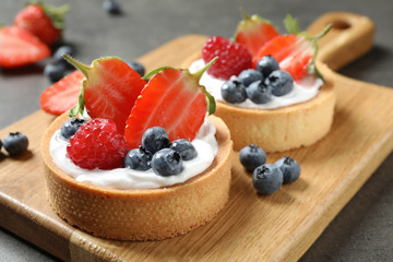 Delicious sweet pastries with berries on grey table, closeup