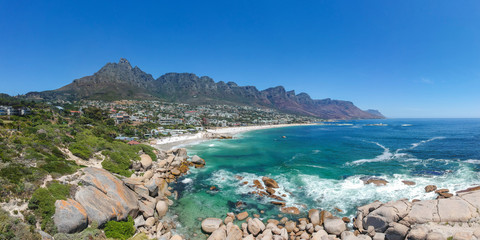 XXL aerial panoramic drone view of Camps Bay, an affluent suburb of Cape Town, South Africa. With its white beach, Camps Bay attracts many tourists. Twelve apostles mountain range in the background.