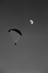 Gleitschirm am Himmel mit Mond im Hintergrund