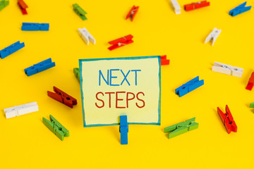 Text sign showing Next Steps. Business photo text something you do or plan after you ve finished something else Colored clothespin papers empty reminder yellow floor background office