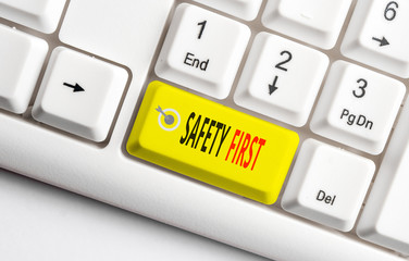 Conceptual hand writing showing Safety First. Concept meaning used to say that the most important thing is to be safe White pc keyboard with note paper above the white background